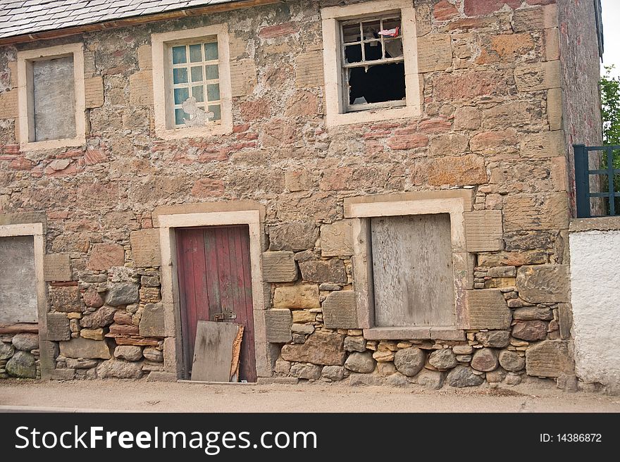 An image of an abandoned property with a wall where the rain and weather have removed the mortar from the lower part of the walls creating the danger of further deterioration and collapse. An image of an abandoned property with a wall where the rain and weather have removed the mortar from the lower part of the walls creating the danger of further deterioration and collapse.