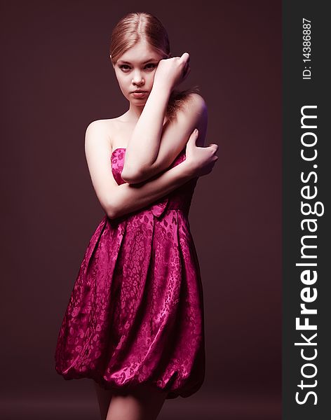 Seductive young woman with naked shoulders wearing on pink dress. Seductive young woman with naked shoulders wearing on pink dress