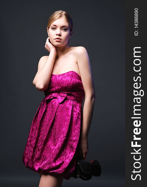 Lovely young woman in pink dress handing shoes. Lovely young woman in pink dress handing shoes