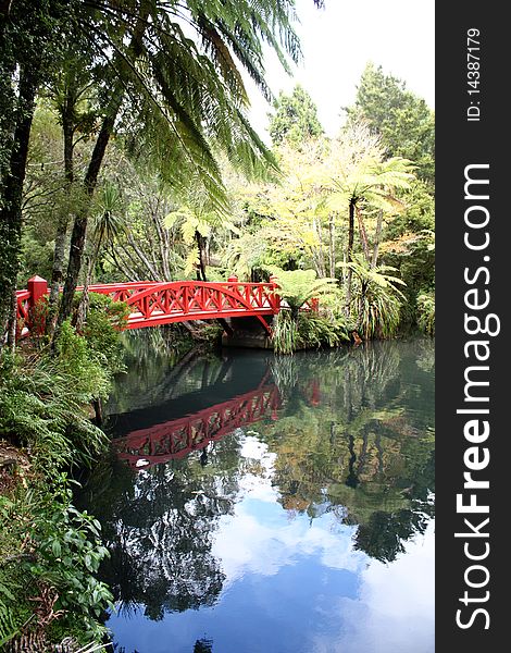 Red bridge over still pond