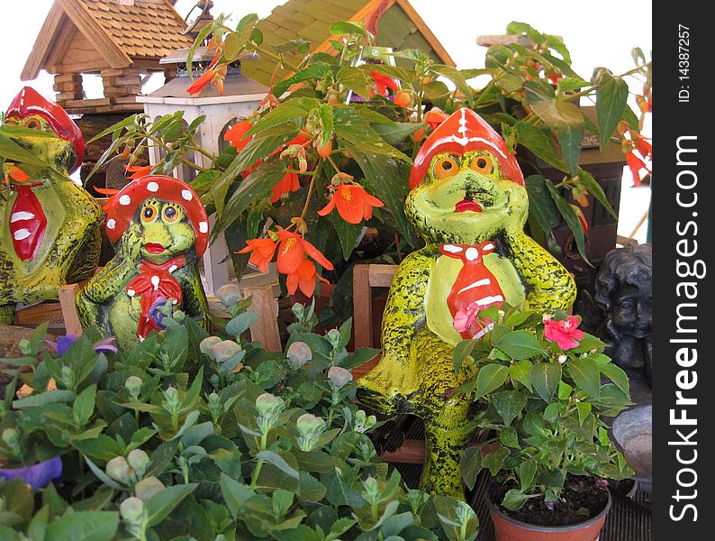 Colorful garden frogs between plants. Colorful garden frogs between plants