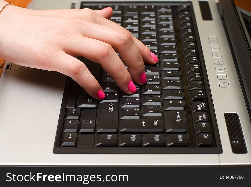 Female hand on the laptop keyboard close up. Female hand on the laptop keyboard close up.