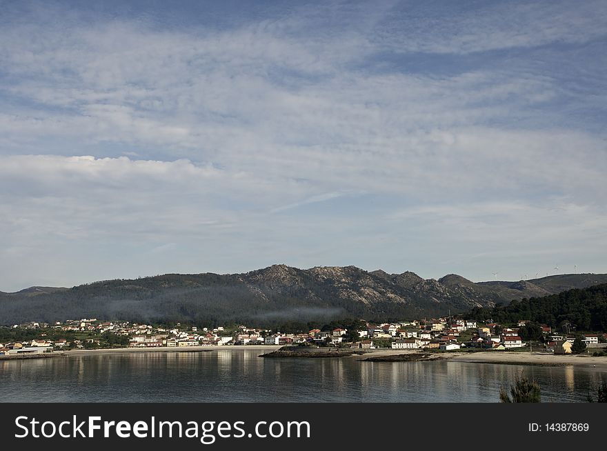 Small fishing village with mountains and sky with clouds. Small fishing village with mountains and sky with clouds