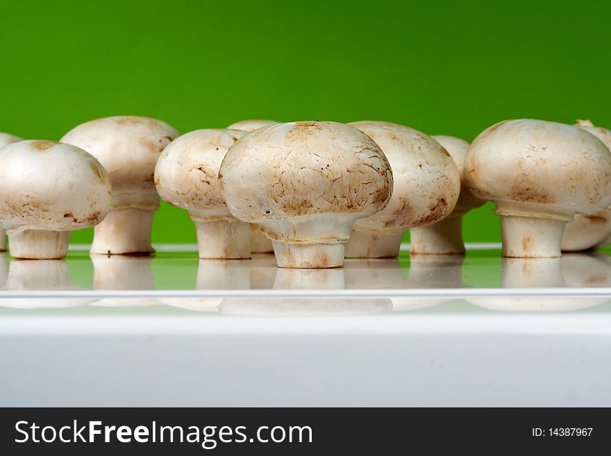 Fresh mushrooms on a white table against the wall