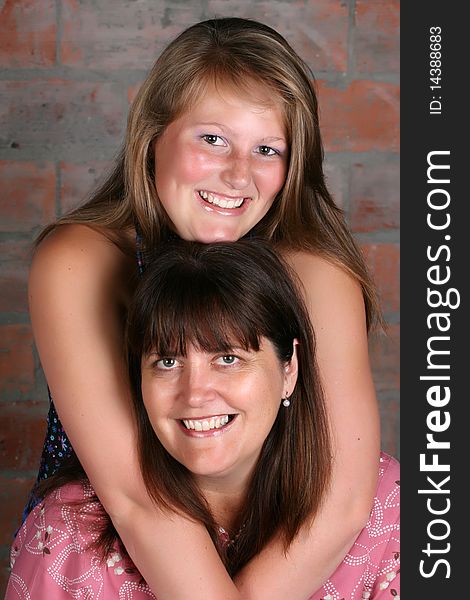 Portrait of mother and daughter against a brick wall background