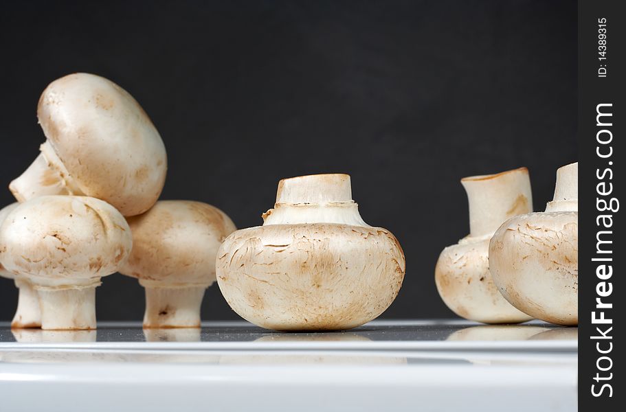 Fresh mushrooms on a white table against the wall