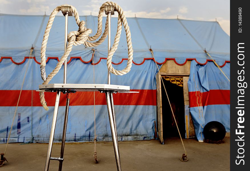 Circus symbolism. A wattled rope on a metal stage personifying plastic acrobats.