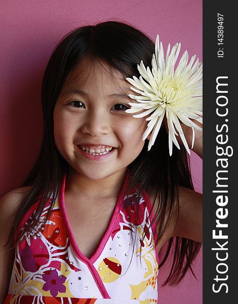 Little asian girl holding flower in her hair. Little asian girl holding flower in her hair