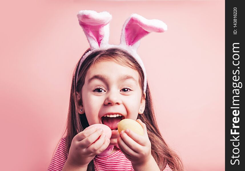 Cute little girl with bunny ears on pink background