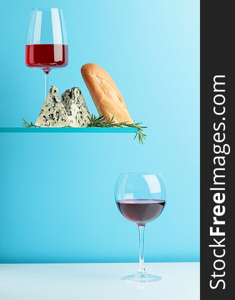Blue cheese with bread, wine and rosemary on a blue background
