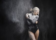 Free Beautiful Slim Girl Wearing A Black Gymnastic Bodysuit Covered With Clouds Of The Flying White Powder Dances On A Dark Background Stock Image - 143832891