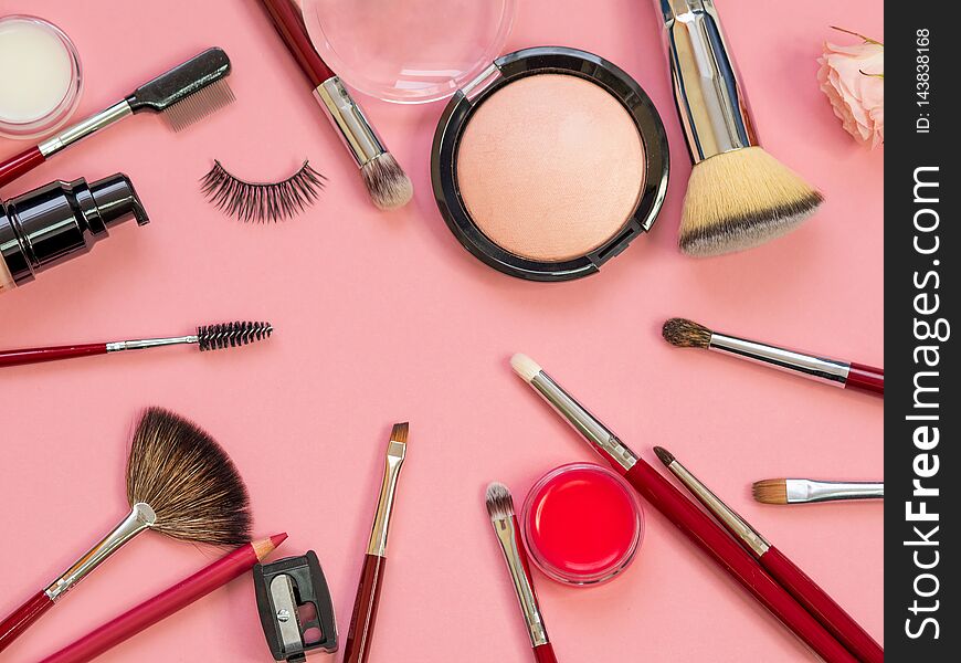 Set for professional makeup, different brushes for applying powder and eyeshadow. Cosmetics and Foundation, concept on pink background