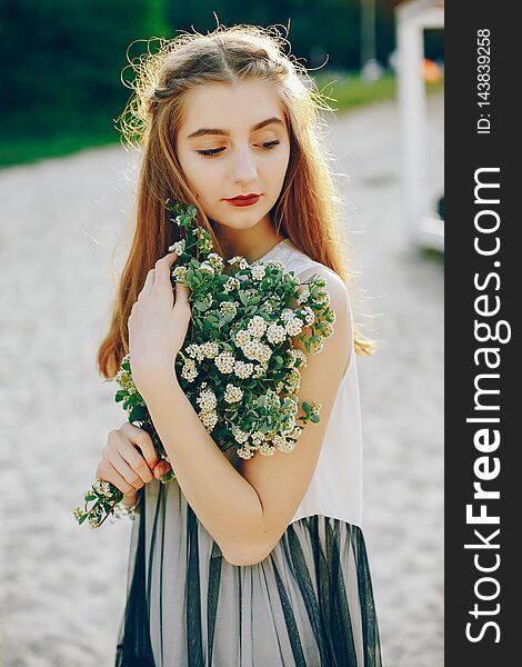 Beautiful girl with bouquet of flowers. Lady have fun in a summer park. Beautiful girl with bouquet of flowers. Lady have fun in a summer park