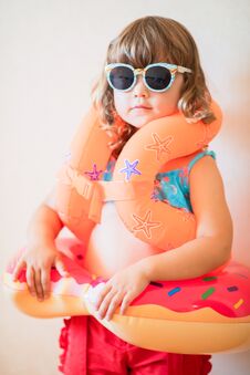 Adorable Little Girl Ready To Go For The Beach, Wearing Sunglasses, Inflatable Over-sleeves Floats And Inflatable Donut Float Ring Stock Image Adorable Little Girl Ready To Go For The Beach, Wearing Sunglasses, Inflatable Over-sleeves Floats And Inflatable Donut Float Ring Stock Image