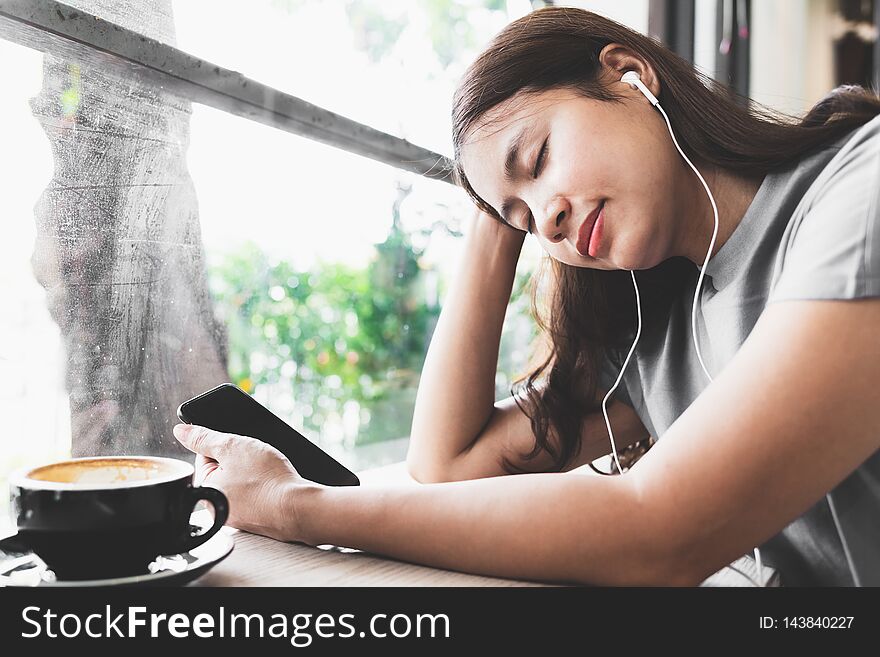 Asian woman feel relaxed, listening to music in the coffee shop. Asian woman feel relaxed, listening to music in the coffee shop