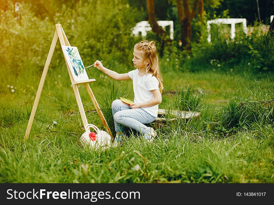 Cute Little Girl Painting In A Park