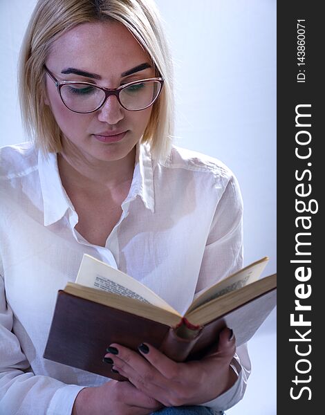 Student girl reading old book with glasses