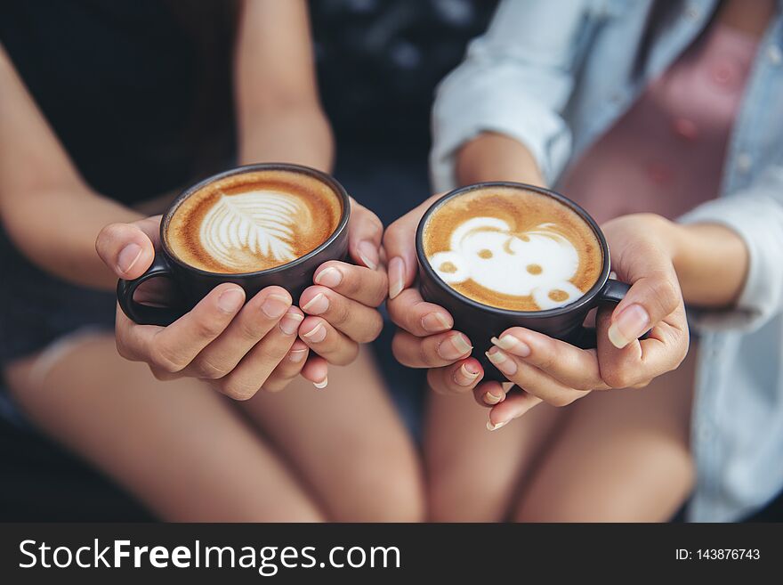 Female hands holding cups of coffee at cafe