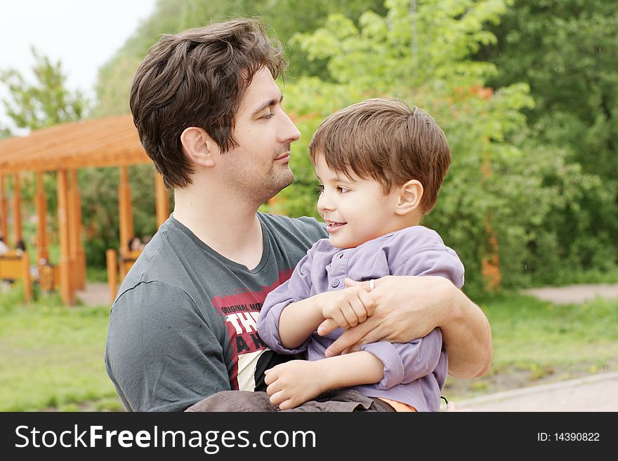 Young father embrace his little smiling son, outdoor shot. Young father embrace his little smiling son, outdoor shot