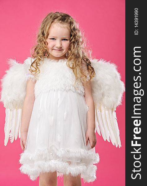 Beautiful little angel girl isolated on pink background