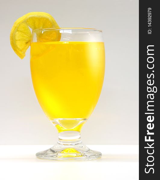 Orange juice glass with lemon on white. Orange juice glass with lemon on white