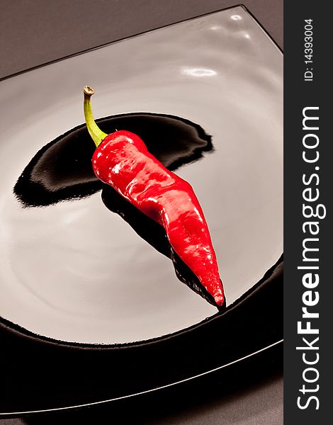 Food series: red hot chilli pepper on black plate. Food series: red hot chilli pepper on black plate