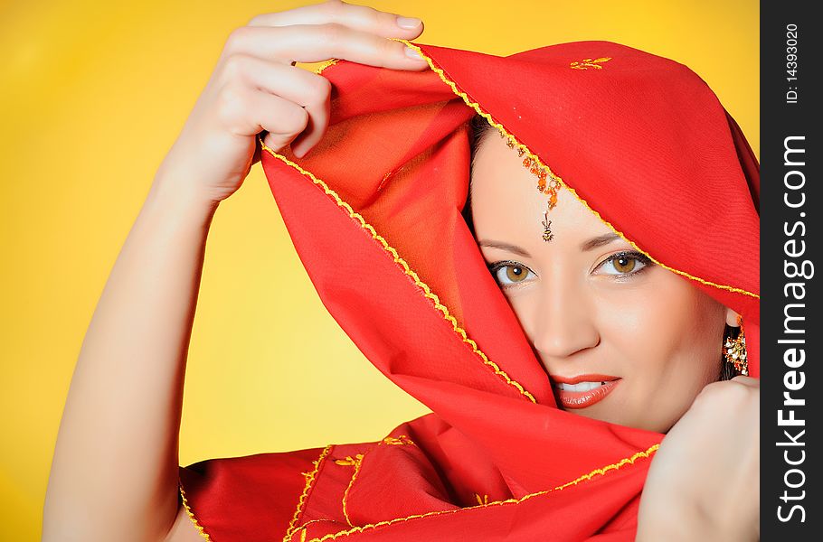 Young beautiful woman eyes in indian traditional jewellary, bindi , sari dress and makeup. yellow background. Young beautiful woman eyes in indian traditional jewellary, bindi , sari dress and makeup. yellow background