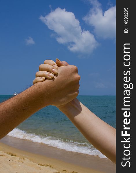 Couple hands in a sky and sea close-up