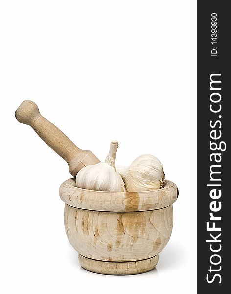 Garlic in a mortar grinder isolated on a white background. Garlic in a mortar grinder isolated on a white background.