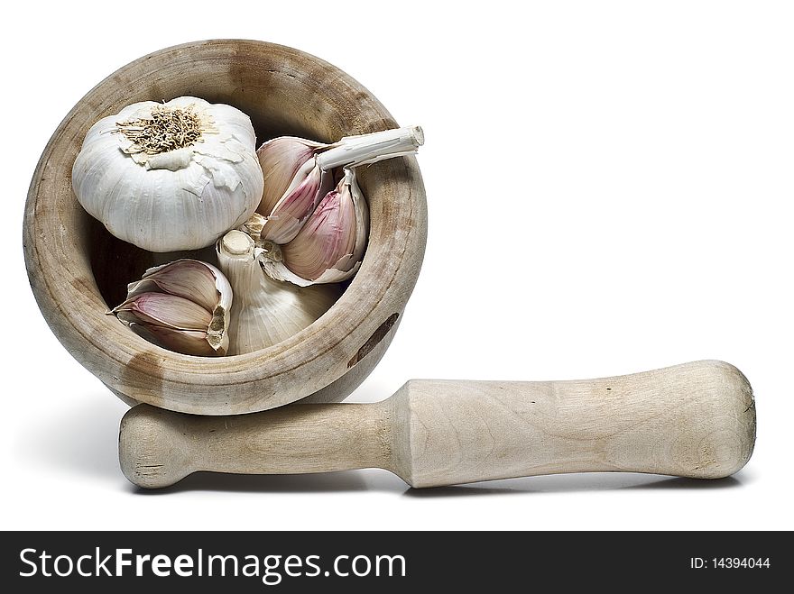 Garlic in a mortar and pestle isolated on a white background. Garlic in a mortar and pestle isolated on a white background.