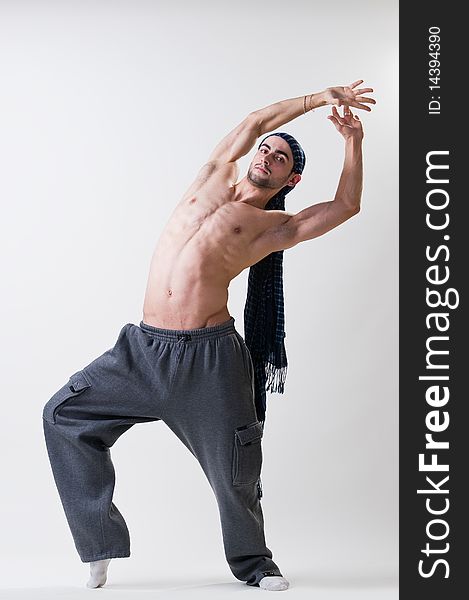 Handsome dancer exercising, studio shot over gray background