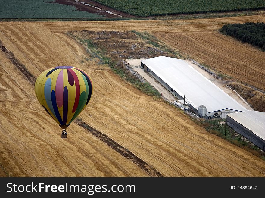 A hot air balloon above fields landscape