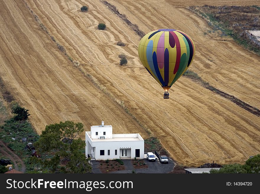 A hot air balloon above fields landscape