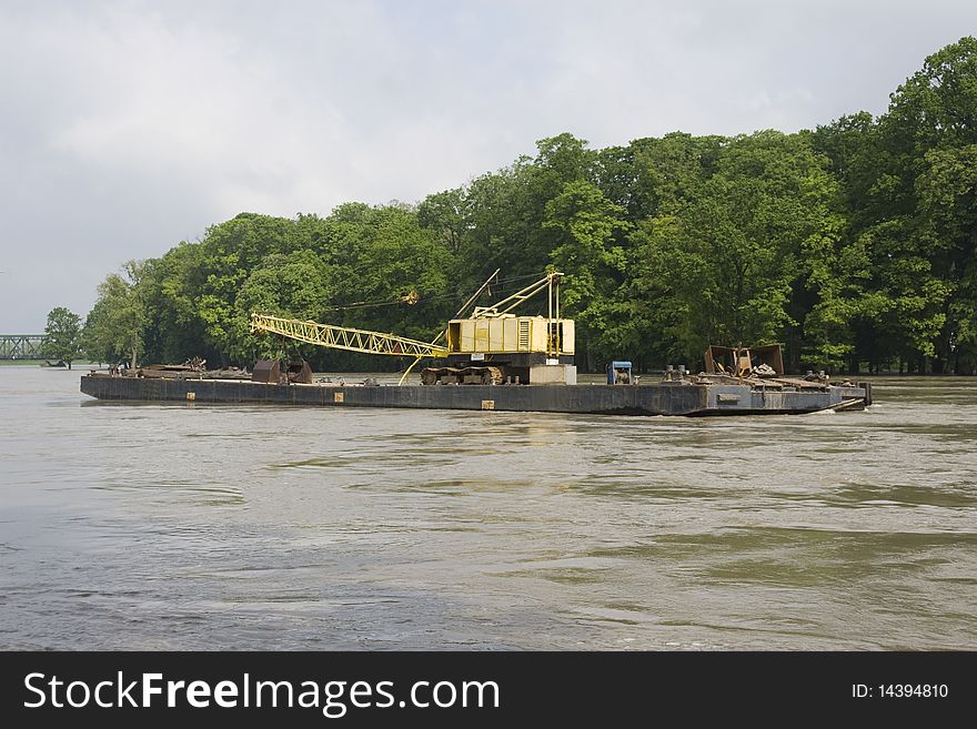 Excavator on the barge during the flood