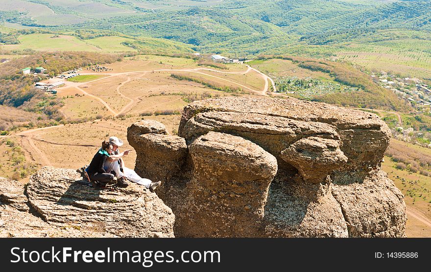 A couple sitting on the rock in Crimean mountains. A couple sitting on the rock in Crimean mountains
