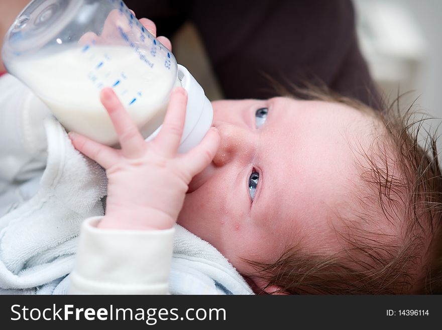 Little baby drinking milk from a bottle with baby bib. Little baby drinking milk from a bottle with baby bib