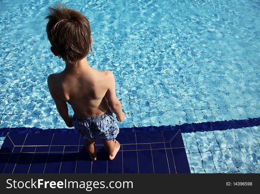 Boy looking to the swimming-pool ready to jump. Boy looking to the swimming-pool ready to jump