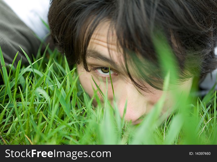 Face of a young man lying on the grass. Eye closeup. Face of a young man lying on the grass. Eye closeup