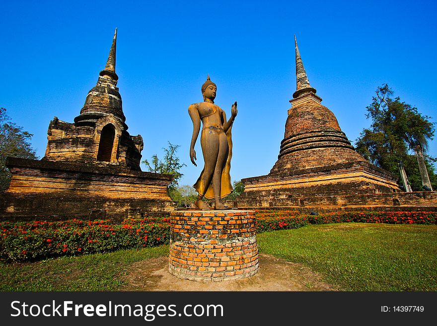 Delicate buddha statue between pagodas in background. Delicate buddha statue between pagodas in background