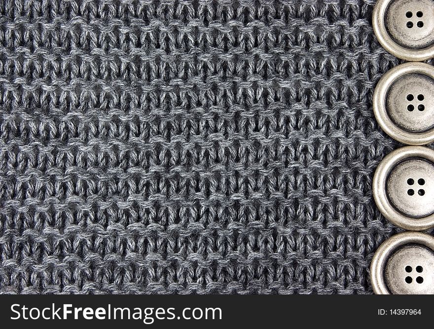 Metal buttons on a gray knitted fabric background. Metal buttons on a gray knitted fabric background