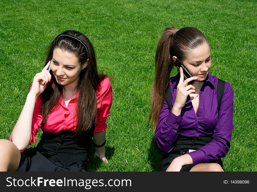 Two young businesswomen calling by phone