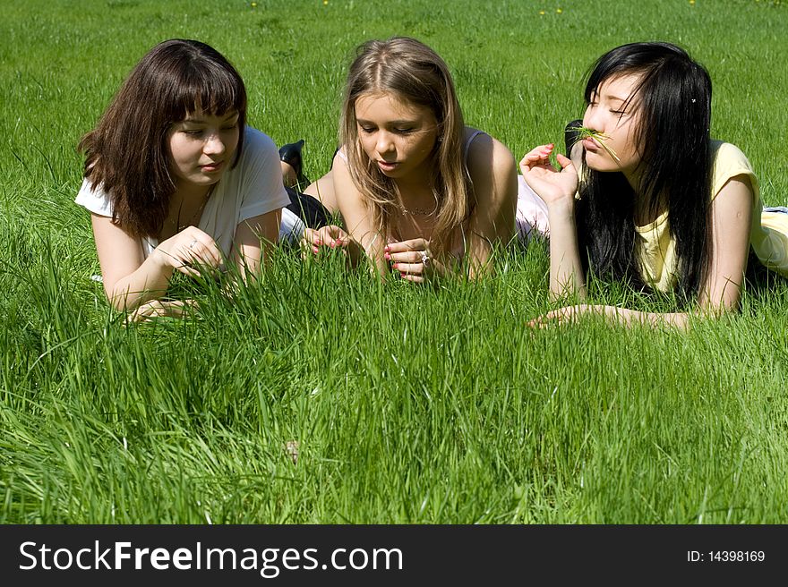 Three girls lying on grass