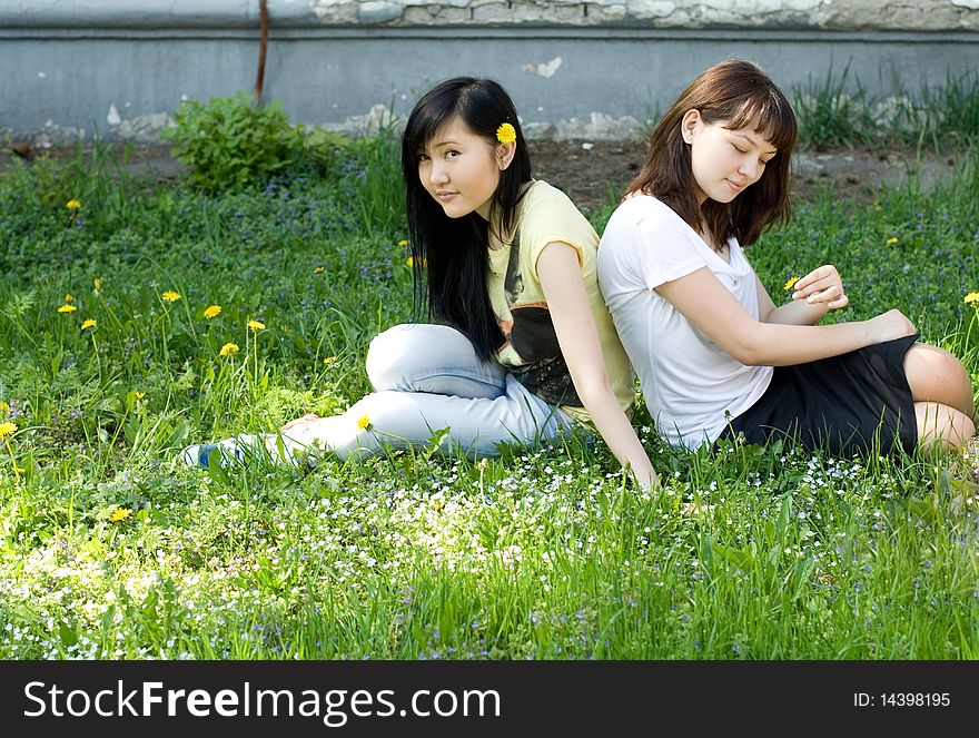 Two girls sitting on grass