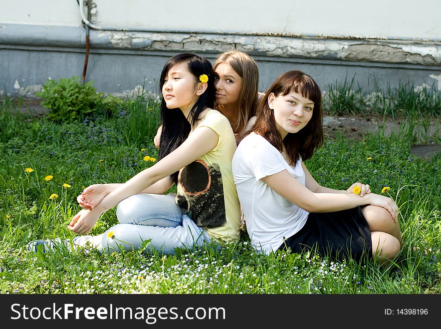 Three girls sitting on grass