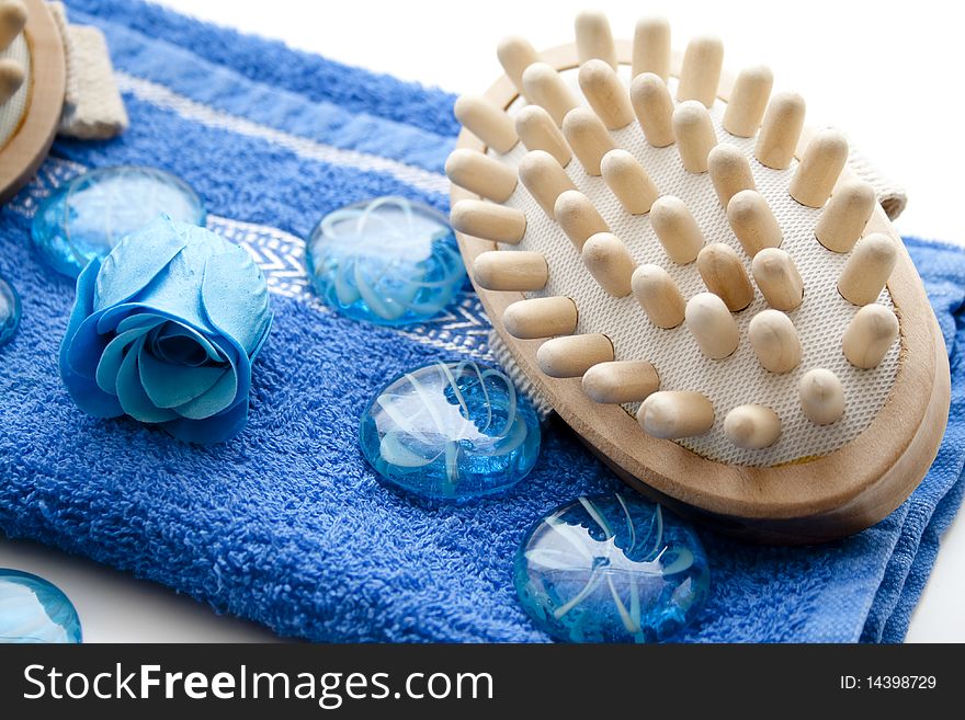 Massage brush on blue towel and stones