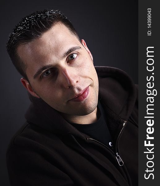 Young man with hoodie portrait on dark background. Young man with hoodie portrait on dark background