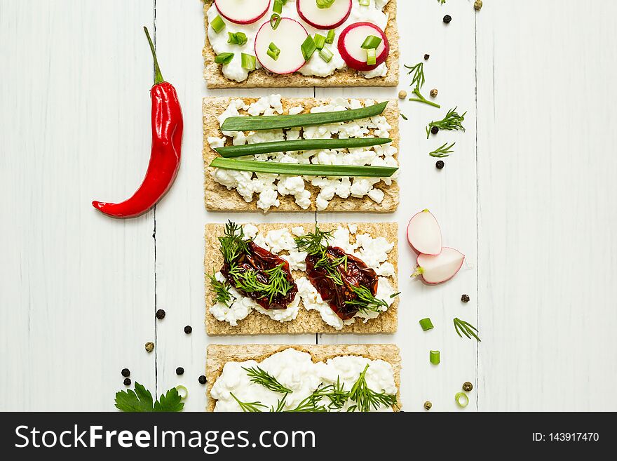 Cheese appetizers with vegetables on a white wooden background. View from above. Healthy eating
