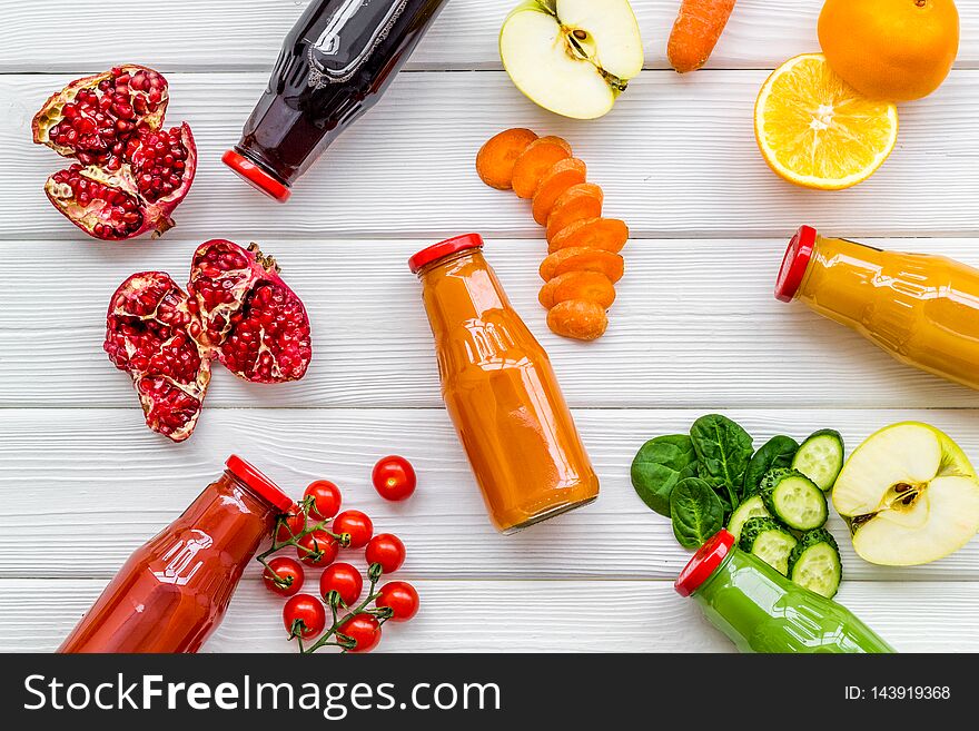 Bottles with fresh carrot, tomato, apple, cucumber, lemon, pomegranate juices on white background top view copyspace