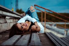 Young Sexy Woman Lies On A Wooden Bench. She Is Taking Break After Workout In Gym. Outdoor Royalty Free Stock Photography