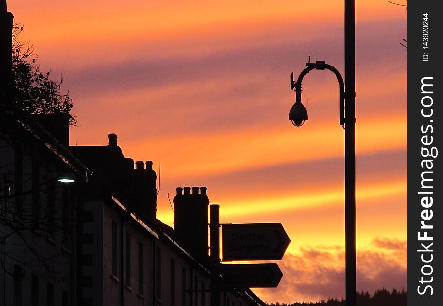 Bands of colored sky during a sunset over a row of terrace houses in England. Bands of colored sky during a sunset over a row of terrace houses in England